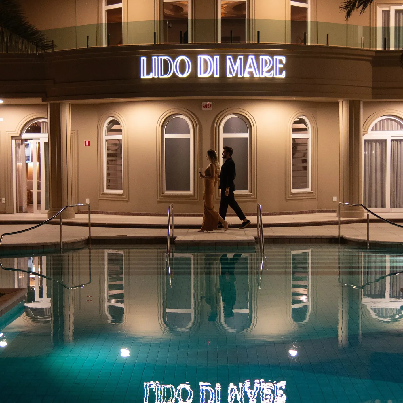 O Lido di Mare à noite, refletido na piscina.