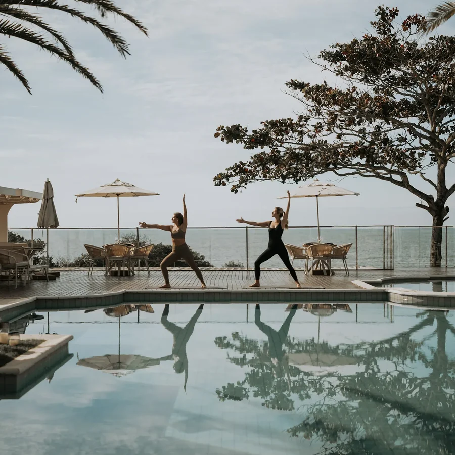 Yoga no deck, com o mar ao fundo.