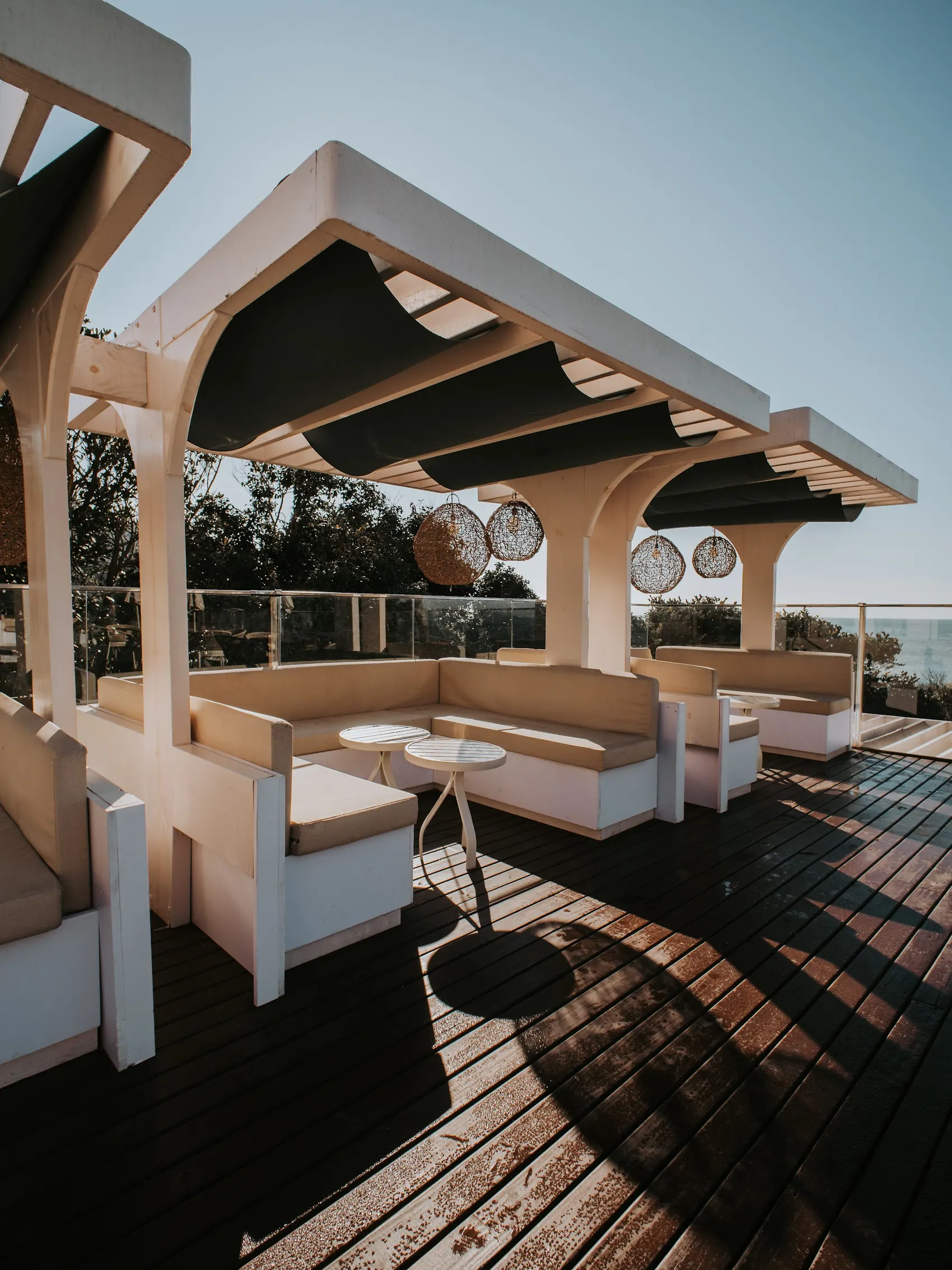 Pérgola e sofás no deck de frente para o mar